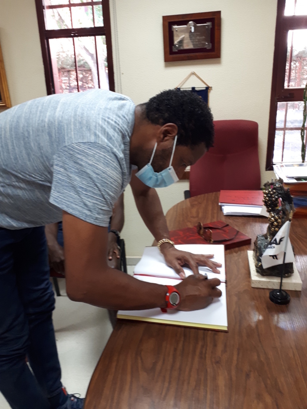 El cubano, firmando en el libro de honor de la Federación Territorial.