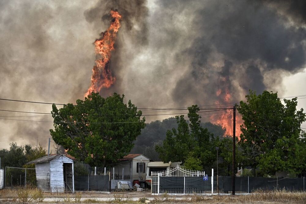 Wildfires lead to evacuations in Greece  / VASILIS PSOMAS