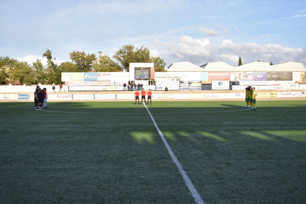 Trío arbitral y equipos en el minuto de silencio.