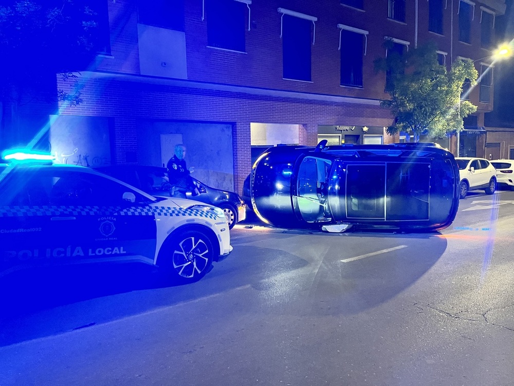 Un coche vuelca en mitad de la calle Camino de la Guija